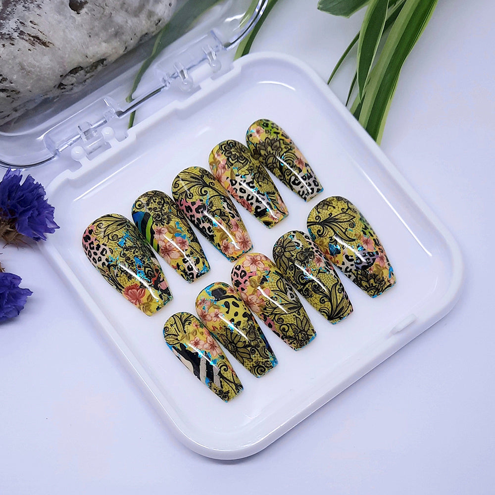 hand made yellow press on nails with a unique design of black lace, flowers, and animal print