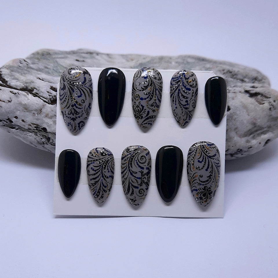 Black and grey hand made press on nails with a decorated black swirl design