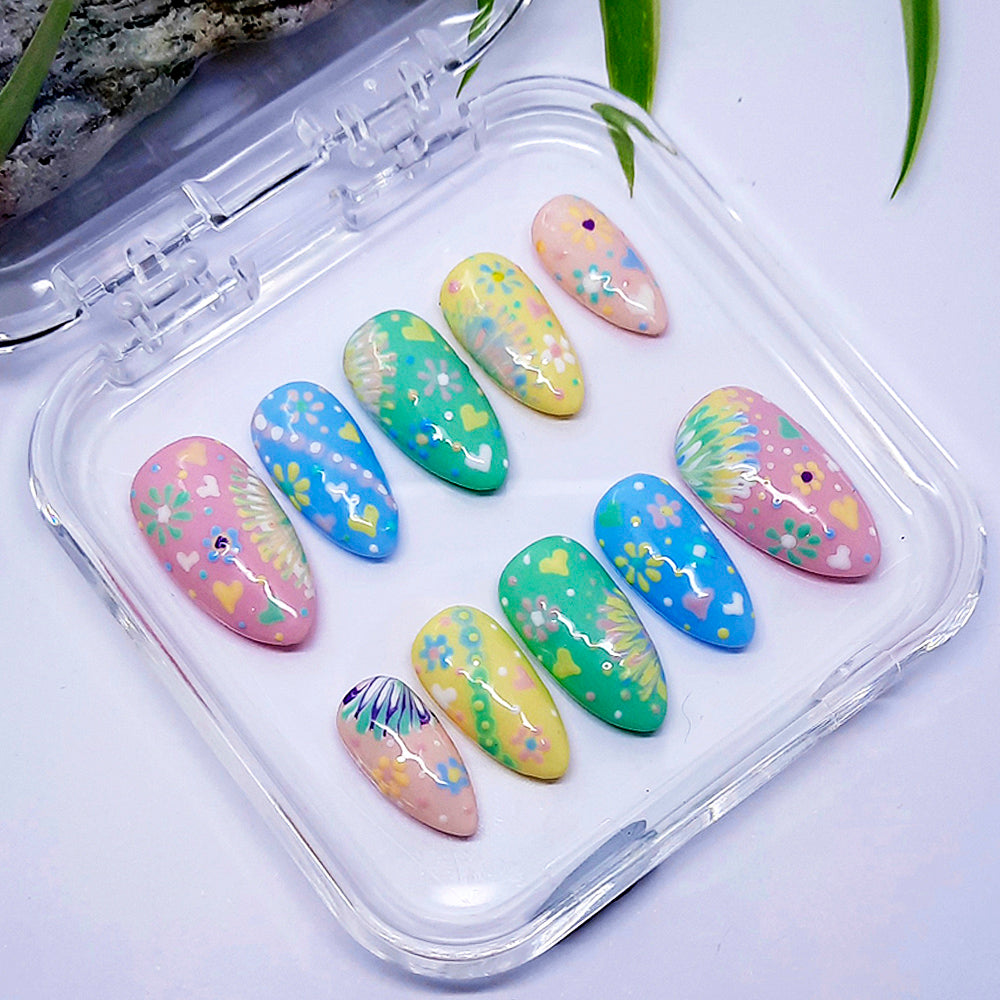 Set of pastel-colored nail art designs in a clear case on a light background
