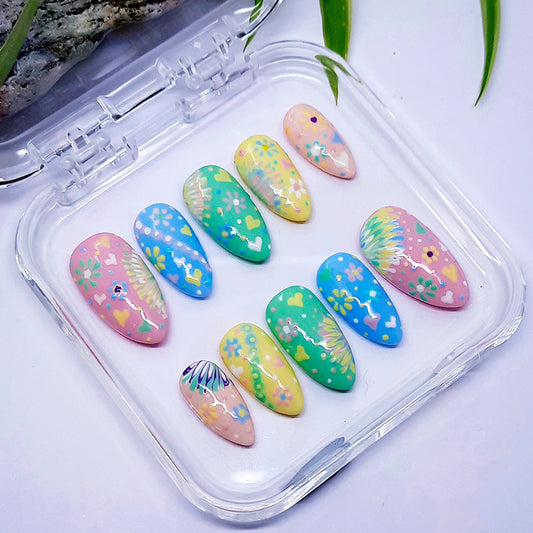 Set of pastel-colored nail art designs in a clear case on a light background