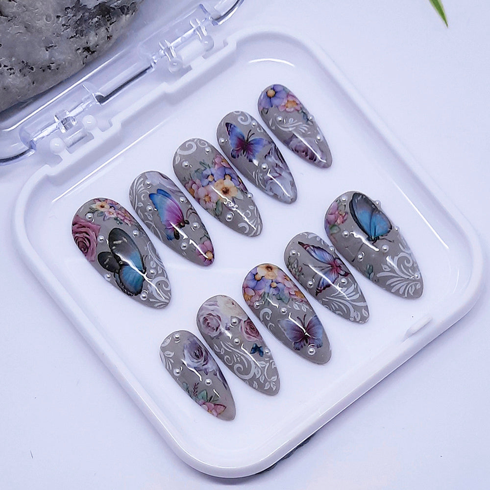 Set of decorative nail art designs in a white case on a light background