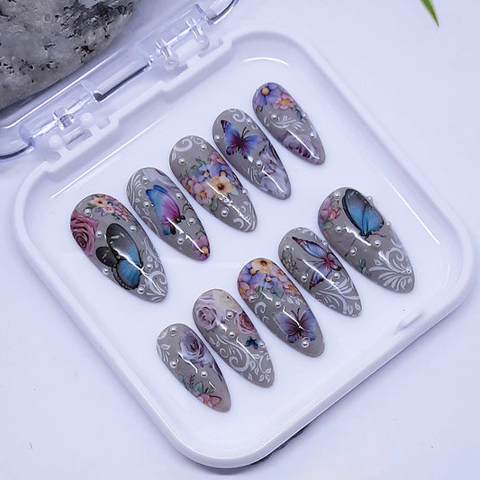 Set of decorative nail art designs in a white case on a light background