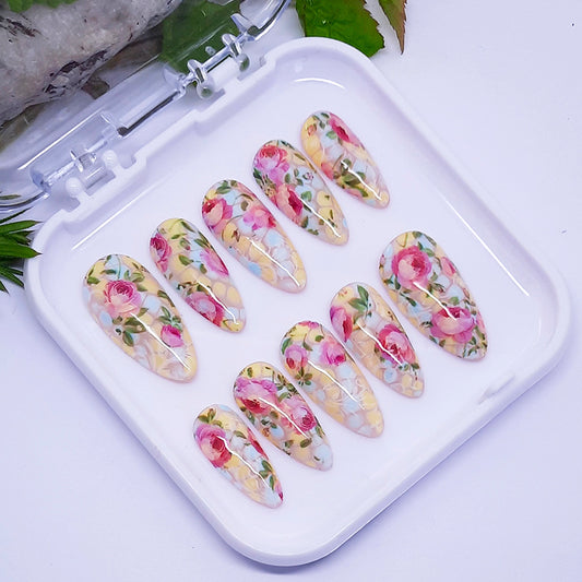 A set of floral nail art designs displayed in a white tray.