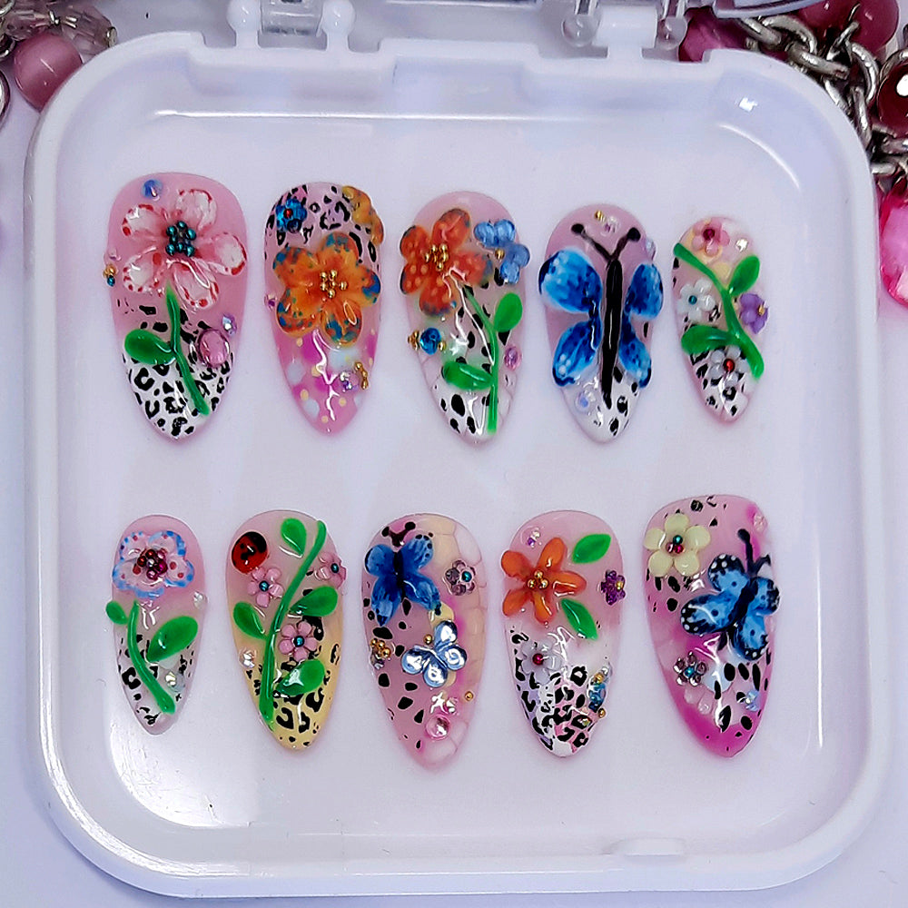 beautiful summer inspired press on nails with hand made flowers and butterflies, with added gems