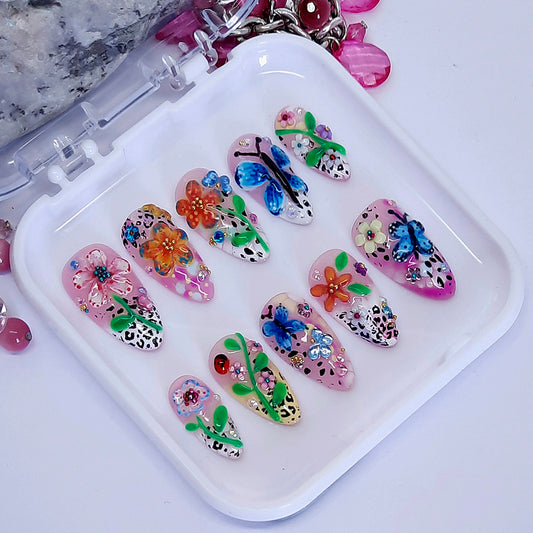 beautiful summer inspired press on nails with hand made flowers and butterflies, with added gems