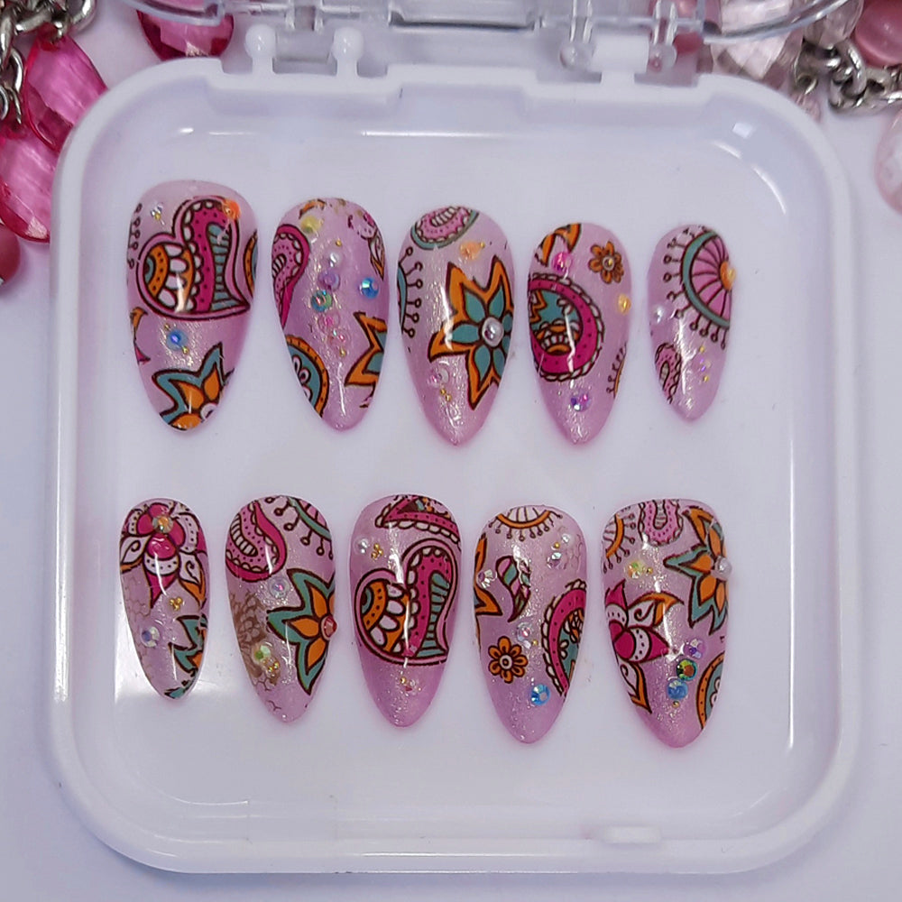 A beautiful shimmery set of press on nails, in a lilac/pink, with a hippy vibe design, with added pearls and sparkly gems