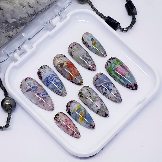 Set of artistic nail art designs on a white tray with a white background.