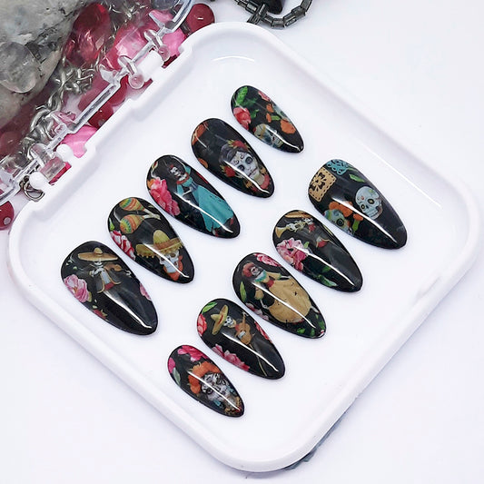 Set of black nail art designs on a white tray with a floral and skull pattern.