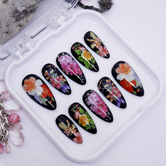 A set of black nails with a colourful floral design.