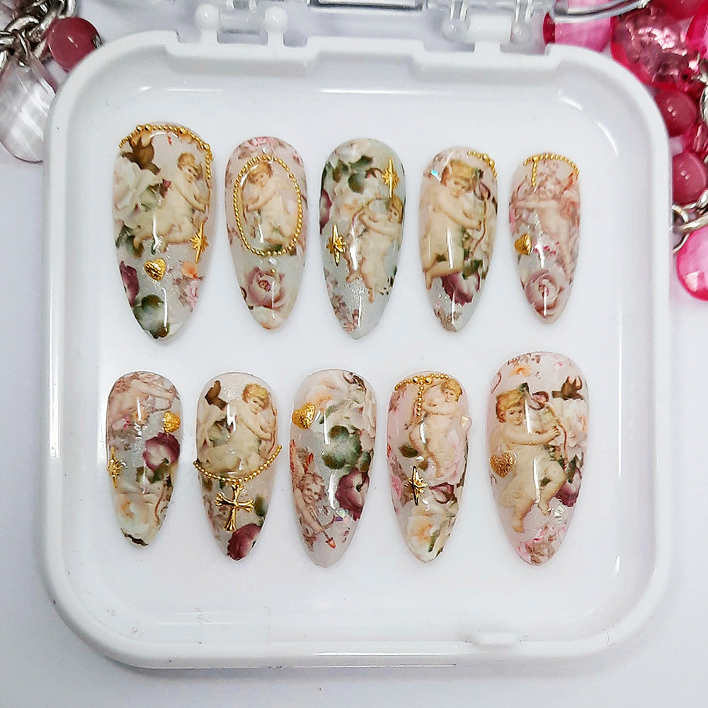 Decorative nail art set with floral and angel designs on a white tray.