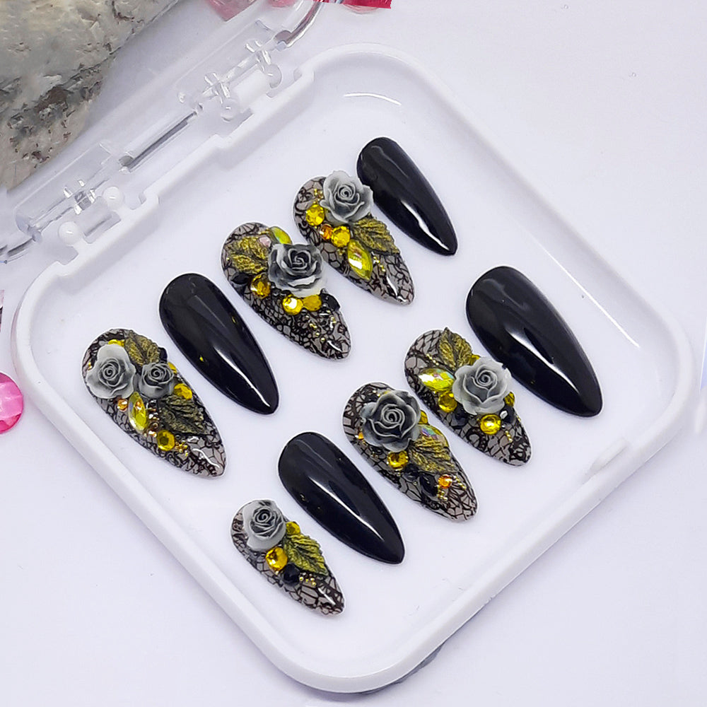 A set 0f black and grey press on nails with black lace and a 3d floral design including crystals.