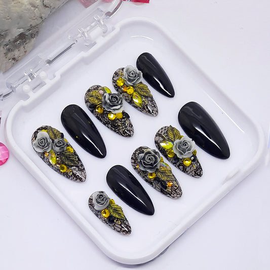 A set 0f black and grey press on nails with black lace and a 3d floral design including crystals.