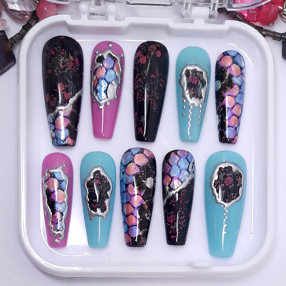 A stunning set of press on nails. In black, pink and blue gel polish, with cherry blossom, metallic snakeskin and silver chrome.