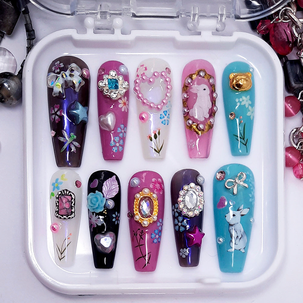 Set of decorated nail art panels in a case with various designs.