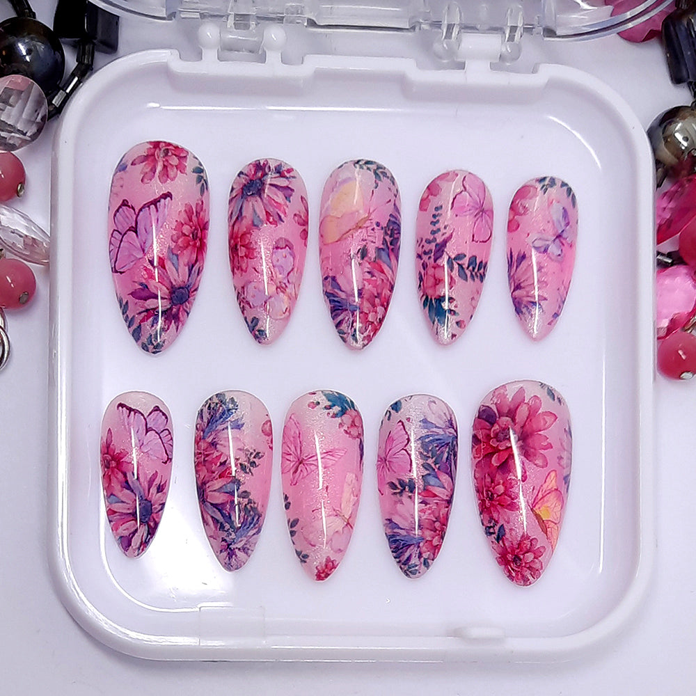 Beautiful press on nails in soft shimmering pink and lilac, with flowers and butterflies. Finished in gloss top coat.
