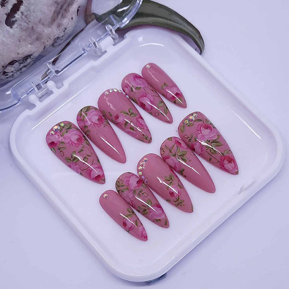 Pretty pink press on nails with pink roses and crystals, finished with a glossy top coat.