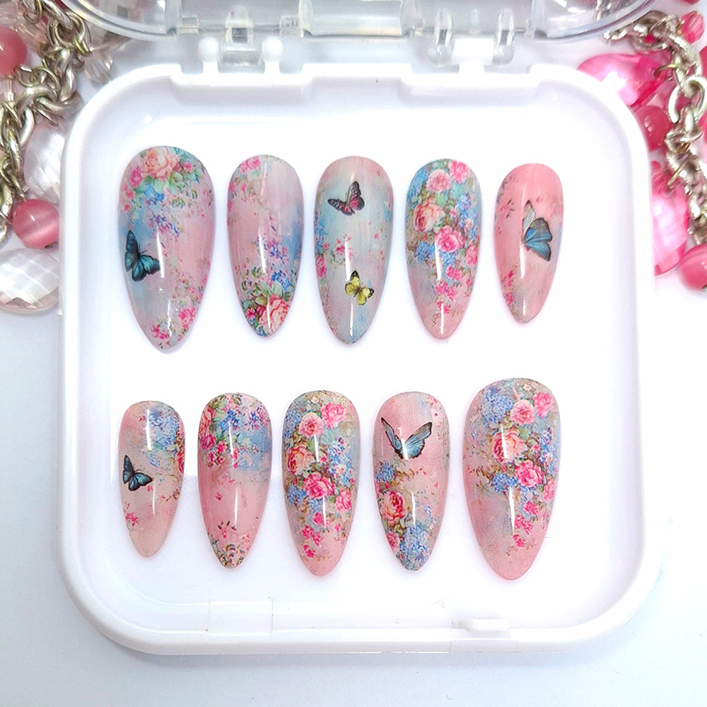 Set of decorative nail art with floral and butterfly designs on a white tray.