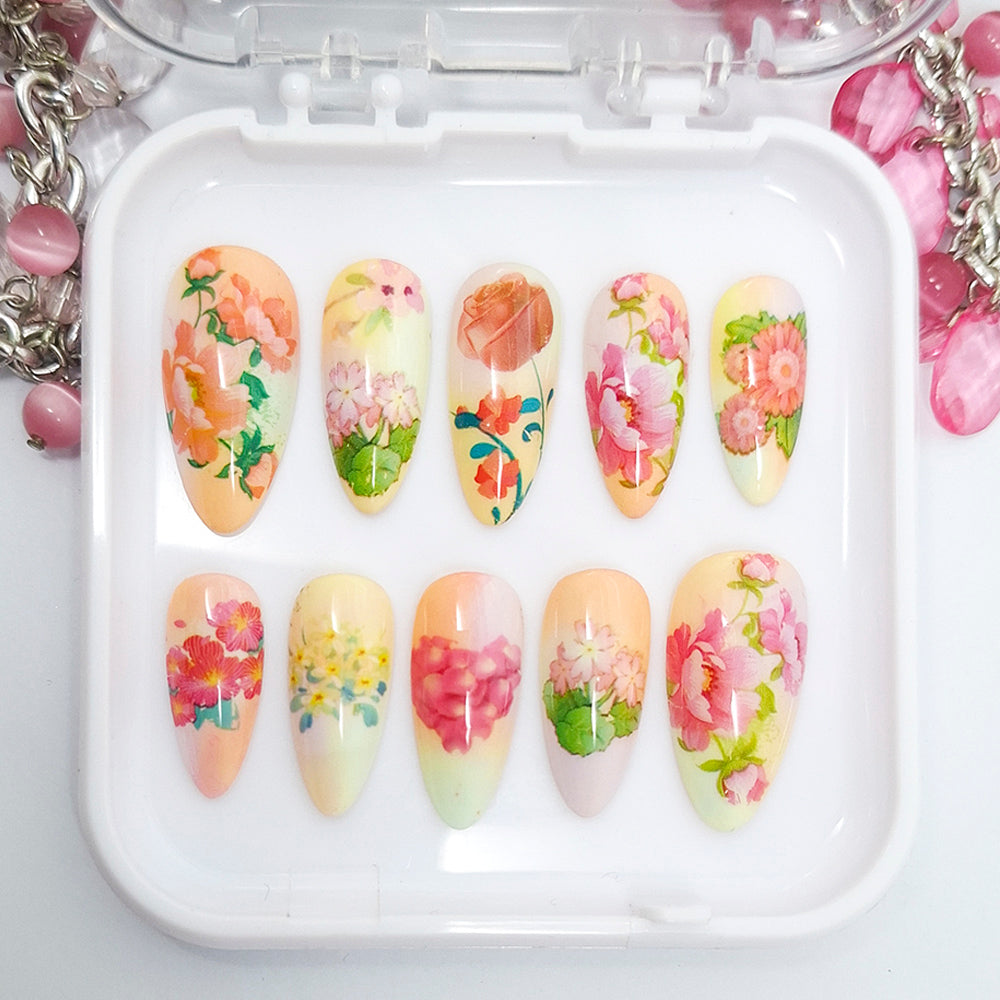 Set of floral nail art designs in a white case with decorative elements.