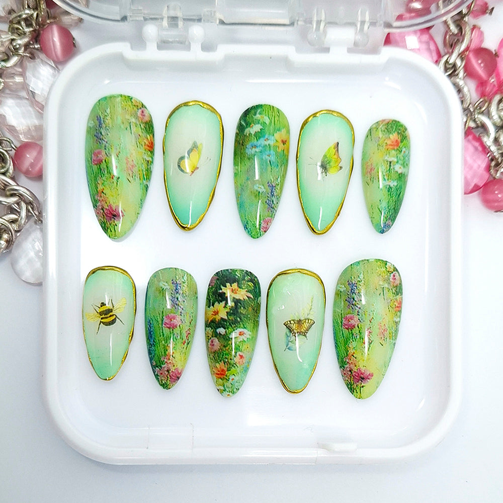 Set of green nail art designs with floral and butterfly patterns on a white tray.