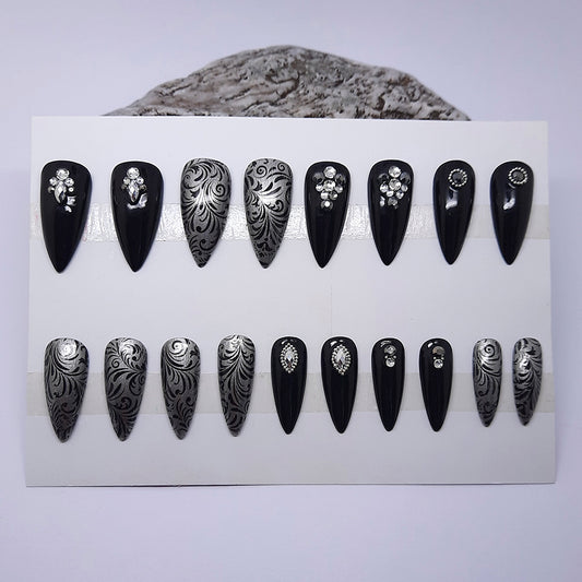 a beautiful set of hand made press on nails, in black and silver with black vines and 3d nails art