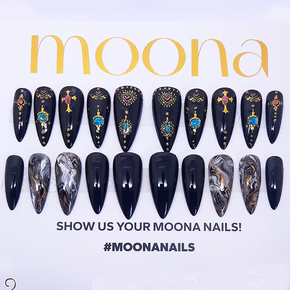 2 sets of black press on nails with designs of marble and gold hearts and crosses. Displayed on a white background