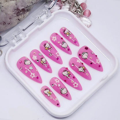 Pink nail art designs with Hello Kitty on a white tray