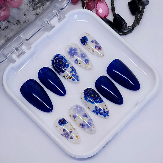 Gorgeous dark shimmering blue and milky white press on nails with blue flowers. Finished with a glossy top coat.