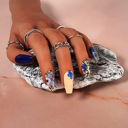 hand made coffin press on nails in blue and fawn with an animal print and flower design and 3d flowers on the accent nail