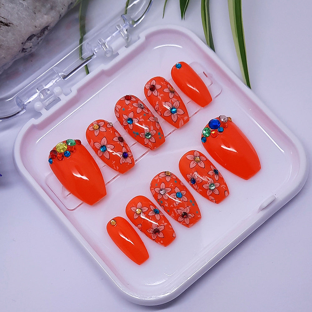 Gorgeous orange press on nails with flowers and a coloured gem at the centre, finished with a glossy top coat.