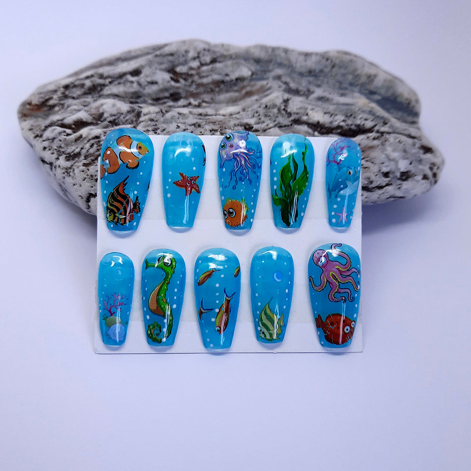 hand made press on nails in blue with an underwater design of fish, star fish etc