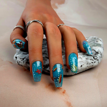 hand made press on nails in blue with an underwater design of fish, star fish etc
