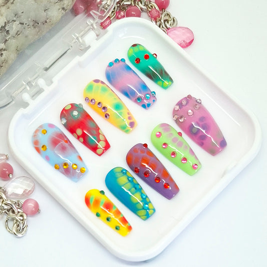 Colorful nail art designs on a white tray with decorative elements.