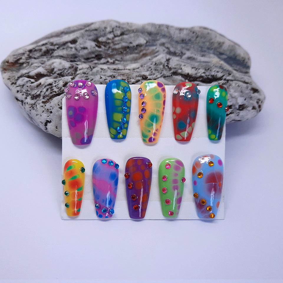hand made press on nails with a tie dye design and added gems