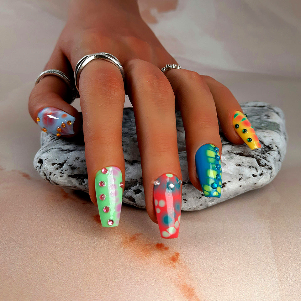 hand made press on nails with a tie dye design and added gems