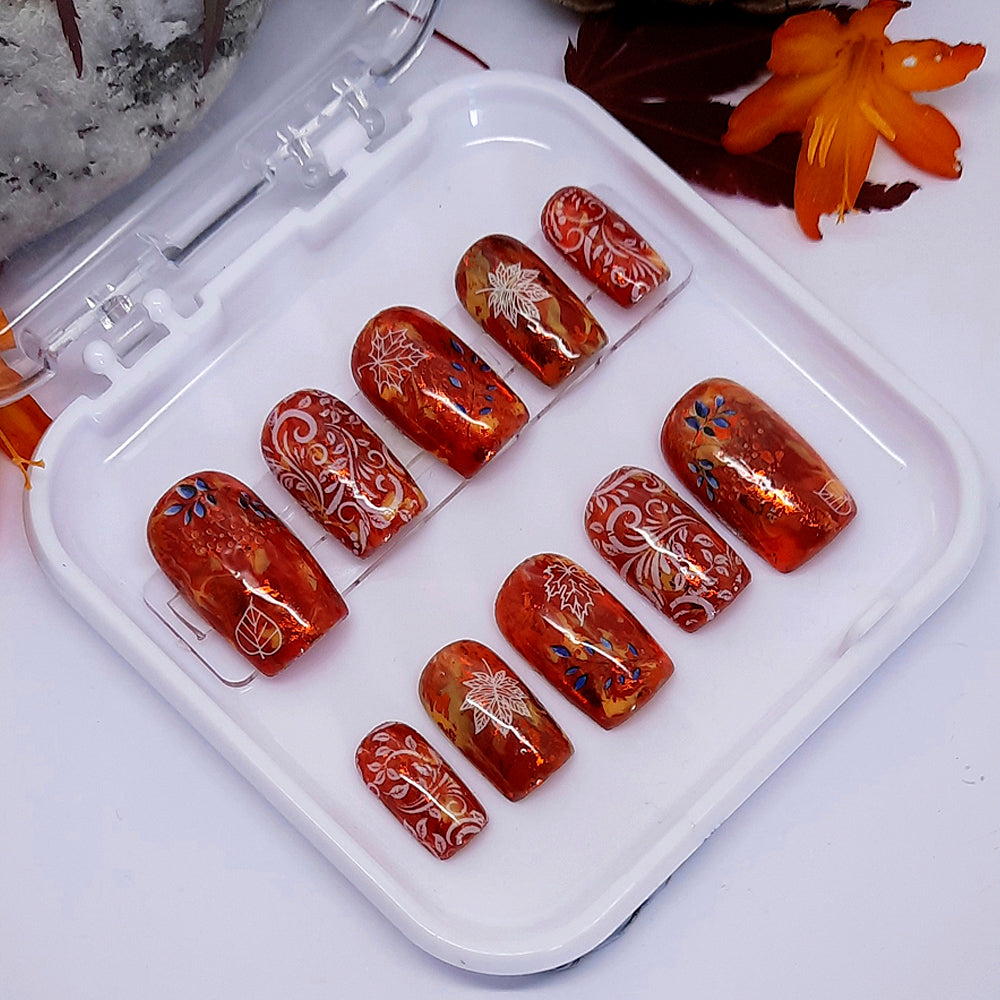 Beautiful press on nails in Autumn colours with white swirls and leaves