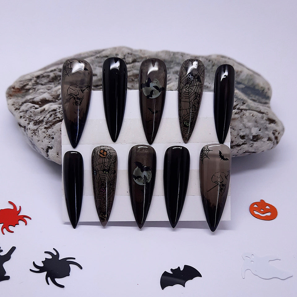 halloween press on nails. Black,in solid and semi sheer gel, with bats, spider webs, moon etc