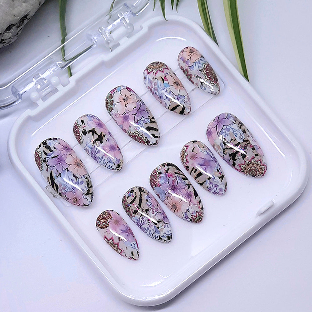 Set of floral and zebra print nail art designs on a white tray.