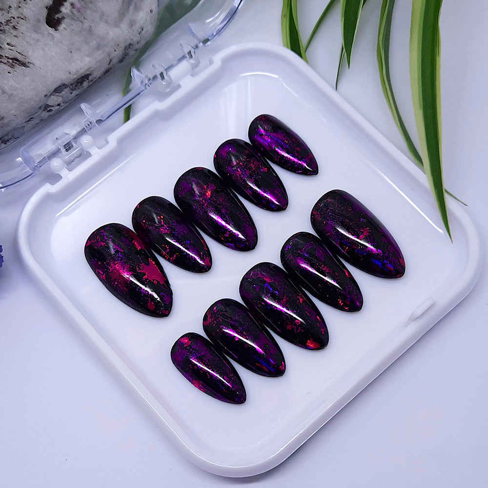 Obsessed with these press on nails! Glossy black with flecks of pink and purple foils.