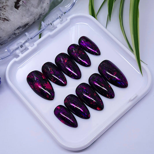 Obsessed with these press on nails! Glossy black with flecks of pink and purple foils.