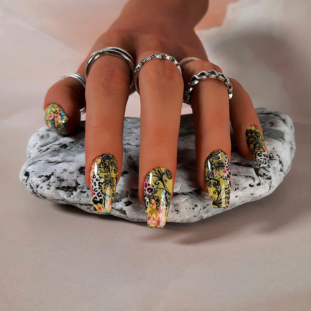yellow hand made press on nails with an abstract design of animal print, black lace and flowers. Pictured in medium coffin.