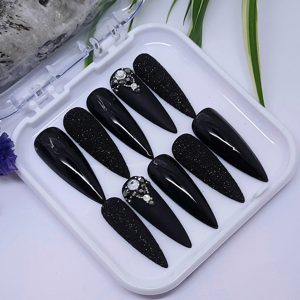 We love these press on nails so much! Black with glitter and gems. Finished with both a matte and glossy top coat apart from the glitter nails, as we wanted to keep the texture and sparkle,.