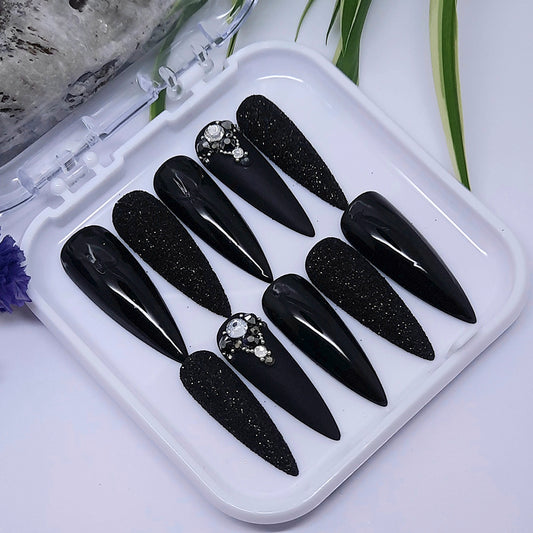 We love these press on nails so much! Black with glitter and gems. Finished with both a matte and glossy top coat apart from the glitter nails, as we wanted to keep the texture and sparkle,.