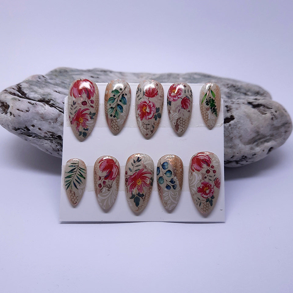 beautiful hand made short almond press on nails, in a creamy gel colour, with flowers and leaves