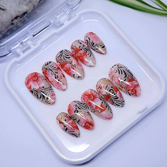 A beautiful set of hand made press on nails, with a design of flowers, black vines, and gold mesh.