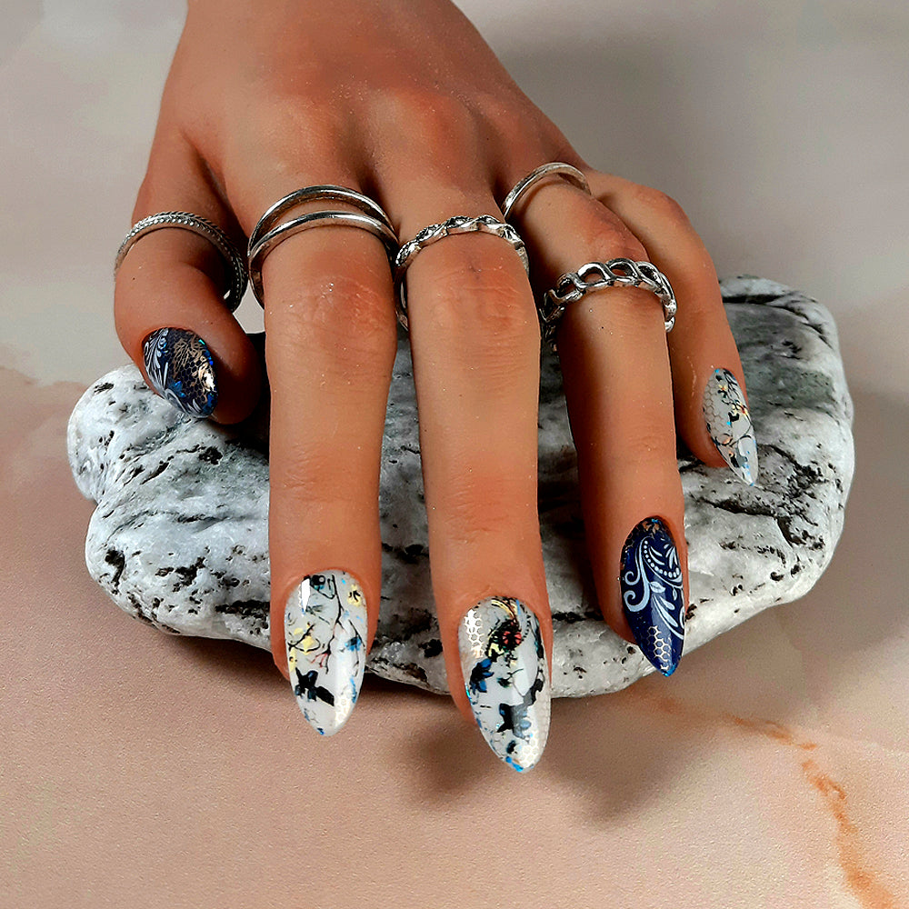 Beautiful almond hand made press on nails in dark blue and milky white, with flowers, vines, and gold mesh.