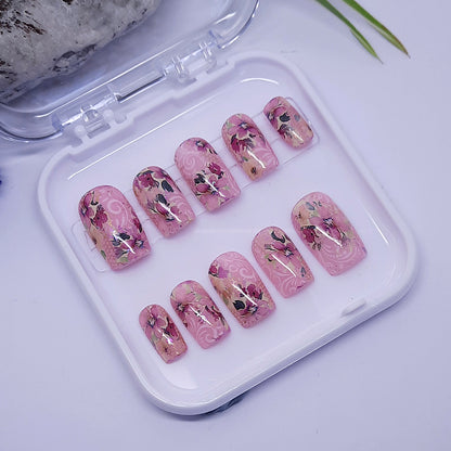 Pretty pink hand made press on nails in short square, with flowers.