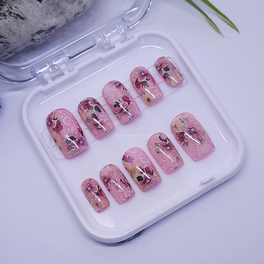 Pretty pink hand made press on nails in short square, with flowers.