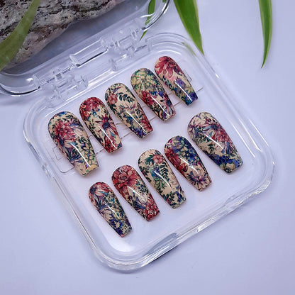 A beautiful set of hand made coffin press on nails in a soft cream gel polish, and covered in flowers and leaves.