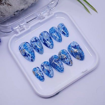 Beautiful blue hand made extra short almond press on nails with flowers and leaves.