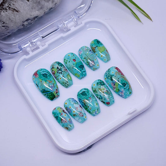 Beautiful green hand made short coffin press on nails with an abstract flower design.